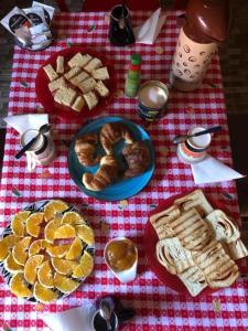 a table with plates of bread and pastries on it at Hosteria NAMAJU in Puerto Iguazú