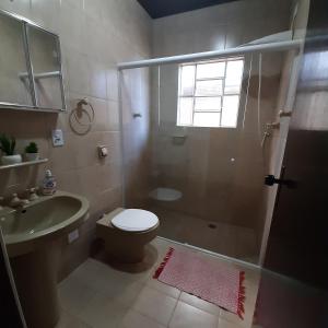 y baño con ducha, aseo y lavamanos. en Casa Avelar Campos do Jordão, en Campos do Jordão