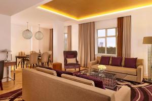 a living room with a couch and a dining room at Sheraton Grand London Park Lane in London