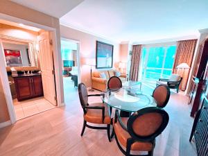een woonkamer met een eettafel en stoelen bij Strip view 1 BR suite 2 Full Bath Full Kitchen with Balcony - 900 sqft - MGM Signature in Las Vegas