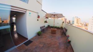 - un balcon avec une table et un parasol dans l'établissement Atrium Miraflores Hotel, à Lima