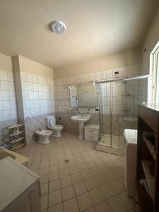 uma casa de banho com 2 WC, um chuveiro e um lavatório. em StartApart City Center em Durrës