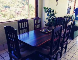 a wooden table and chairs in a room with a table at Vista Bahia Zihua in Zihuatanejo