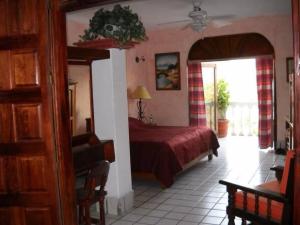 a bedroom with a bed with a red comforter at Vista Bahia Zihua in Zihuatanejo