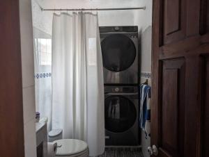 a bathroom with a toilet and a washer and dryer at Vista Bahia Zihua in Zihuatanejo +13 photos