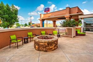 un patio avec des chaises et un foyer extérieur en face d'un bâtiment dans l'établissement SpringHill Suites by Marriott Oklahoma City Moore, à Moore