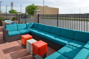 オクラホマシティにあるSpringHill Suites by Marriott Oklahoma City Airportの青いソファ、パティオ(オレンジ色の椅子2脚付)