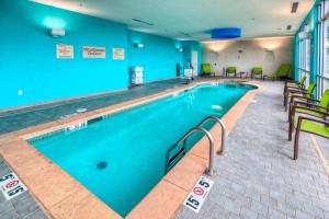 una piscina en una habitación de hotel con sillas alrededor en SpringHill Suites by Marriott Oklahoma City Moore, en Moore