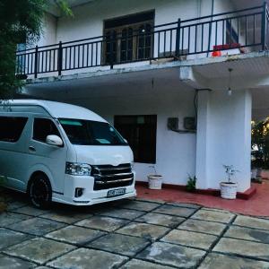 une camionnette blanche garée devant une maison dans l'établissement Adisham village home, à Haputale