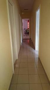 um corredor vazio com piso em azulejo numa casa em AUBERGE-NGOMSON em Brazavile
