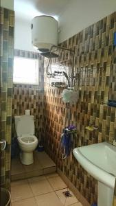 a bathroom with a toilet and a sink at AUBERGE-NGOMSON in Brazzaville