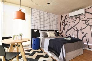 ein Schlafzimmer mit einem Bett und einem Tisch sowie einer Wand mit Graffiti in der Unterkunft Vistas Panorámicas al Parque in Montevideo