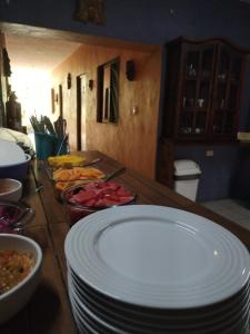 a wooden table with plates and bowls of food on it at Hostel Casa Xtakay in Valladolid