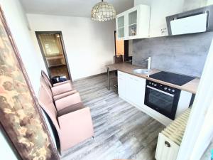 a small kitchen with a pink chair and a sink at Möblierte Wohnung in Sulzbach