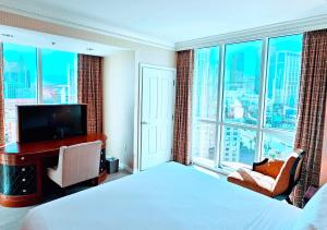 een slaapkamer met een bed, een bureau en een groot raam bij Strip view 1 BR suite 2 Full Bath Full Kitchen with Balcony - 900 sqft - MGM Signature in Las Vegas