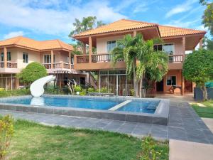 uma villa com piscina em frente a uma casa em แสงหิรัญ บีช รีสอร์ท em Pran Buri