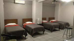 um quarto com três camas num quarto em Hotel Caracoles Colima em Colima