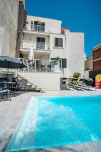 una piscina di fronte a un edificio di Scirocco Holiday House DIAMANTE a Rosolini