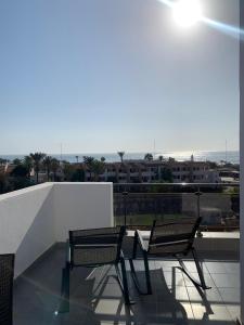 2 sedie su un balcone con vista sulla città di La Suite Hotel-Adults friendly 16 Years plus ad Agadir