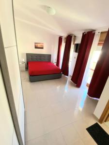 een slaapkamer met een rood bed in een kamer bij Attico sul Mare in Vibo Valentia Marina