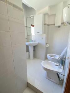een witte badkamer met een toilet en een wastafel bij Attico sul Mare in Vibo Valentia Marina