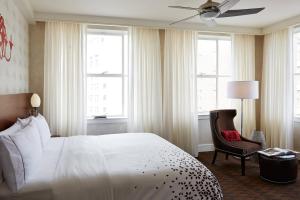 a bedroom with a bed and a chair and windows at Renaissance New Orleans Pere Marquette French Quarter Area Hotel in New Orleans +40 photos
