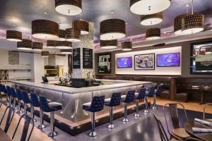 a bar in a restaurant with blue chairs and lights at Renaissance New Orleans Pere Marquette French Quarter Area Hotel in New Orleans