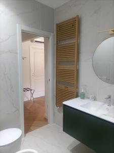 a white bathroom with a sink and a mirror at La luna piena in centro in Pescara