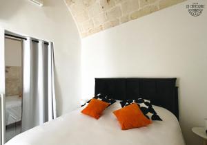 a bedroom with a bed with orange and black pillows at Dimora La Cattedrale - Old Town Charm Suite in Carovigno