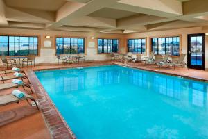 a large swimming pool with chairs and tables at SpringHill Suites Victorville Hesperia in Hesperia