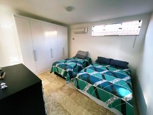 a bedroom with two beds and a counter in it at Casa Mais in Aracaju