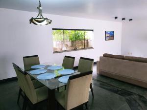 een eetkamer met een tafel en stoelen en een bank bij Casa Mais in Aracaju