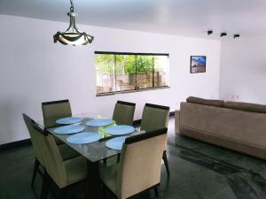 a dining room with a table and chairs and a couch at Casa Mais in Aracaju