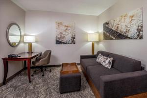 ein Wohnzimmer mit einem Sofa, einem Schreibtisch und einem Spiegel in der Unterkunft SpringHill Suites by Marriott Norfolk Virginia Beach in Virginia Beach