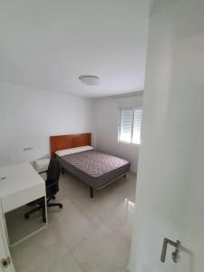 a room with a bed and a desk and a table at Preciosoy gran apartamento terraza con vistas wifi y climatización in Málaga