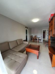 uma sala de estar com um sofá e uma mesa de centro em Preciosoy gran apartamento terraza con vistas wifi y climatización em Málaga