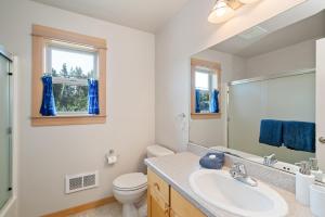 a bathroom with a sink and a toilet and a mirror at Classic Cottage-MCA #1548 in Manzanita +26 photos