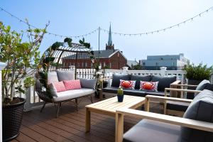 eine Terrasse mit Sofas und einem Tisch auf dem Balkon in der Unterkunft Luxury Federal Hill Home with Rooftop & 4 Parking Spots in Baltimore