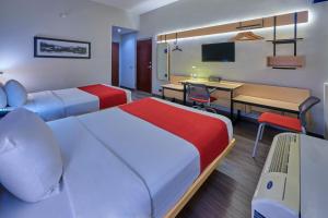 a hotel room with two beds and a desk at City Express by Marriott Saltillo Norte in Saltillo