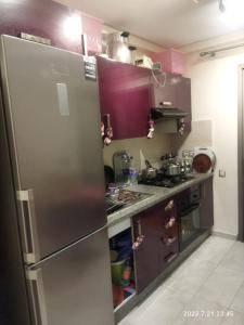 a kitchen with purple cabinets and a stainless steel refrigerator at Marbella Beach îlot 5 in Mansouria