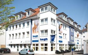 un edificio blanco con carteles a un lado. en hogh Hotel Heilbronn, en Heilbronn