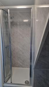 a shower with a glass door in a bathroom at The AppleTree in West Drayton