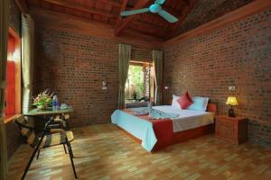 una camera da letto con un muro di mattoni, un letto e un tavolo di Tam Family Homestay a Ninh Binh