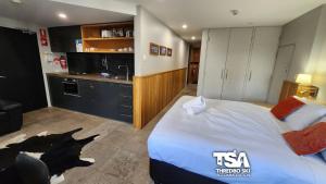 Una habitación de hotel con una cama grande y una cocina. en Powder 3A, en Thredbo