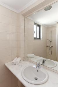 uma casa de banho branca com um lavatório e um espelho em Hotel Africa em Rodes