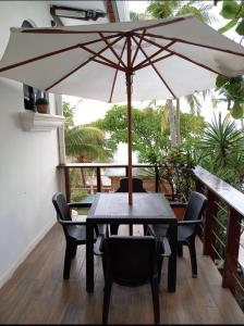 a table and chairs with an umbrella on a porch at Konchamar in La Libertad