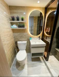 ein Badezimmer mit Toilette, Waschbecken und Spiegel in der Unterkunft Apartement M-Town Avery Type Studio Gading Serpong Tangerang by HokiHome in Tangerang