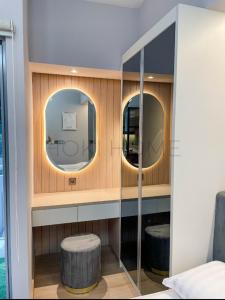 ein Badezimmer mit zwei Spiegeln, einem Stuhl und einem Spiegel in der Unterkunft Apartement M-Town Avery Type Studio Gading Serpong Tangerang by HokiHome in Tangerang