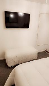 a bedroom with a bed and a tv on a wall at Private luxurious space in Basildon