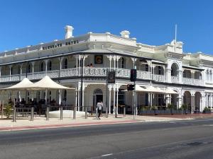 a large white building on the corner of a street at Golden Sands in Henley Beach South